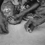 Nach der täglichen Ausgabe der nötigsten Nahrungsmittel an die Flüchtlingsfamilien sammeln Frauen die auf den Boden verbliebenen Getreidekörner auf.
