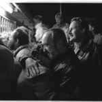 Öffnung der Mauer am 9. November 1989, gegen 23:00 Uhr: die neue Regelung für Privatreisen ist "ab sofort" in Kraft getreten. DDR-Bürger Ostberlins stehen am Grenzübergang "Heinrich-Heine-Straße" und warten nun auf den freien Durchlass nach Westberlin. Ein älteres Ehepaar liegt sich glücklich in den Armen.